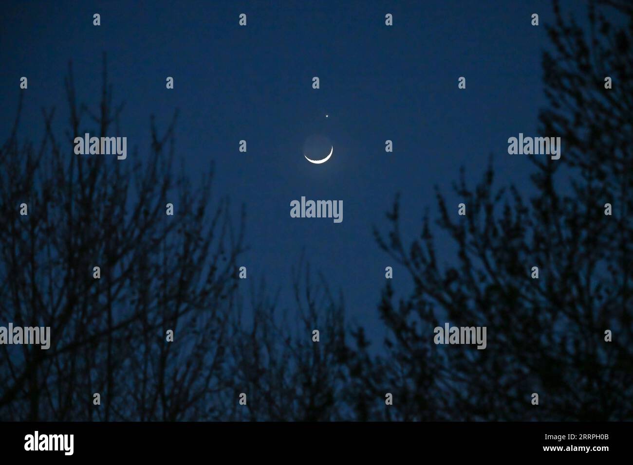 230324 -- PECHINO, 24 marzo 2023 -- il pianeta Venere e la luna crescente sono raffigurati a Pechino, capitale della Cina, 24 marzo 2023. CHINA-BEIJING-LUNAR OCCULTATION OF VENUS CN LIXXIN PUBLICATIONXNOTXINXCHN Foto Stock