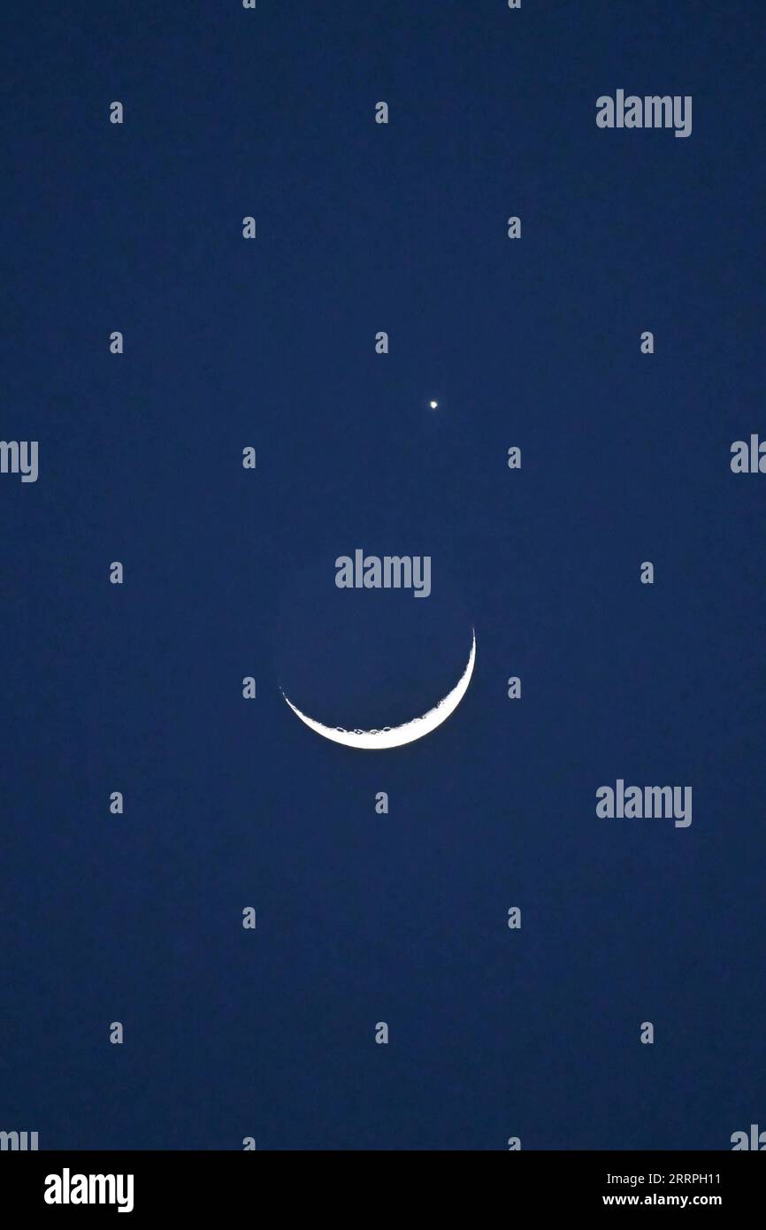 230324 -- PECHINO, 24 marzo 2023 -- il pianeta Venere e la luna crescente sono raffigurati a Pechino, capitale della Cina, 24 marzo 2023. CHINA-BEIJING-LUNAR OCCULTATION OF VENUS CN LIXXIN PUBLICATIONXNOTXINXCHN Foto Stock