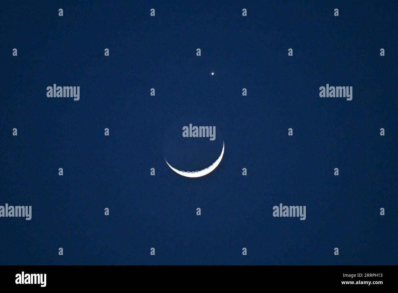 230324 -- PECHINO, 24 marzo 2023 -- il pianeta Venere e la luna crescente sono raffigurati a Pechino, capitale della Cina, 24 marzo 2023. CHINA-BEIJING-LUNAR OCCULTATION OF VENUS CN LIXXIN PUBLICATIONXNOTXINXCHN Foto Stock