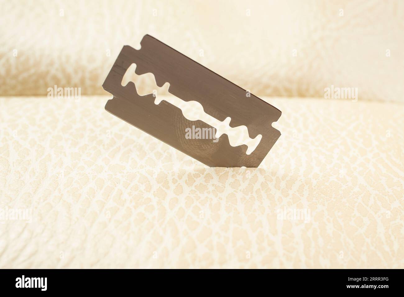 Lama per rasoi con texture in pelle beige, messa a fuoco morbida in primo piano Foto Stock