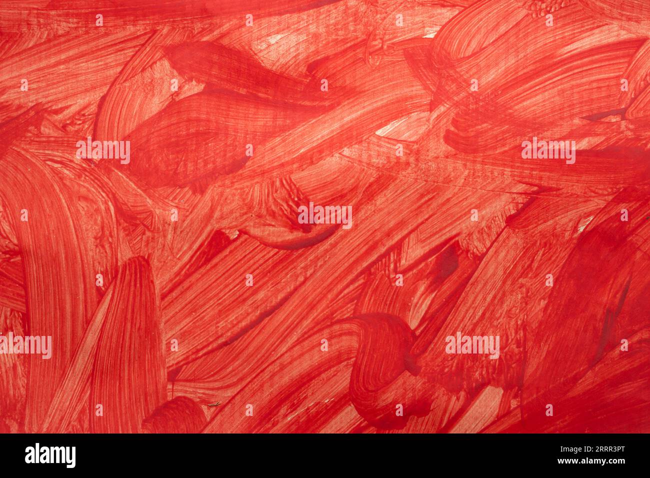 Spruzzi di vernice rossa e tratti di pennello sulla grana della carta, primo piano Foto Stock