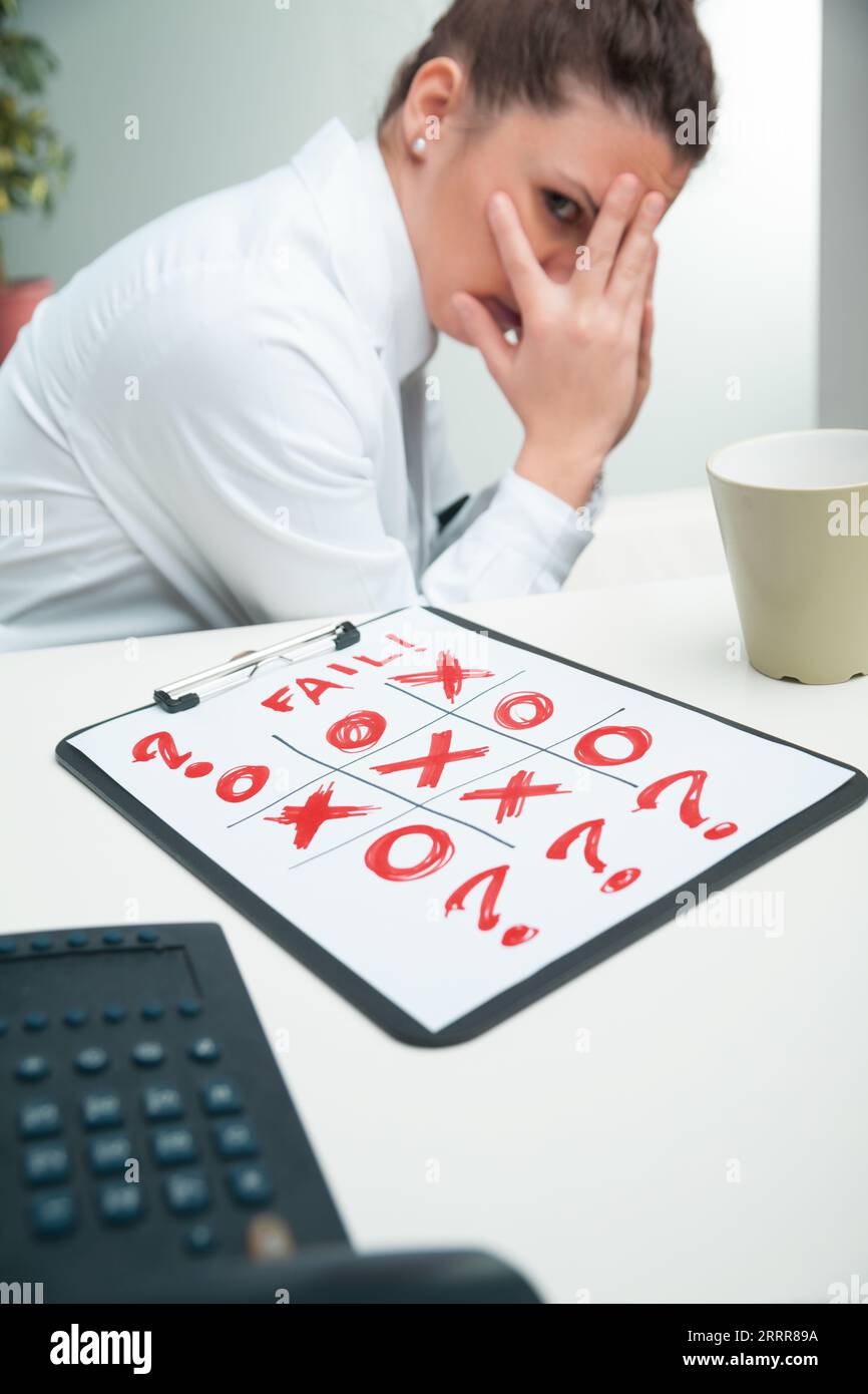 Scienziato, raffigurato con TIC-TAC-Toe, si afferra con un problema irrisolto. Nel suo cappotto da laboratorio, si allontana dalla sfida intimidatoria, Symbo Foto Stock