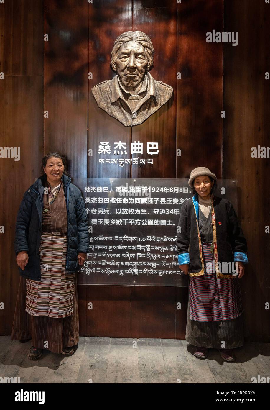 230613 -- YUMAI, 13 giugno 2023 -- Zhoigar R e Yangzom posano per una foto con la scultura del loro padre Sangye Quba presso la Yumai Township nella città di Shannan, nella regione autonoma Tibet del sud-ovest della Cina, 10 giugno 2023. Situata al confine tra Cina e India, Yumai Township era una volta nota come la città meno popolata della Cina. Per un lungo periodo a partire dagli anni '1960, fu abitata da una sola famiglia composta da Yangzom, Zhoigar e il loro padre Sangye Quba, che morì nel 2001. Prima della morte di Sangye Quba, egli espresse la sua convinzione che l'autorità avrebbe sviluppato bene Yumai. Oggi, il desiderio di Sangye Quba Foto Stock