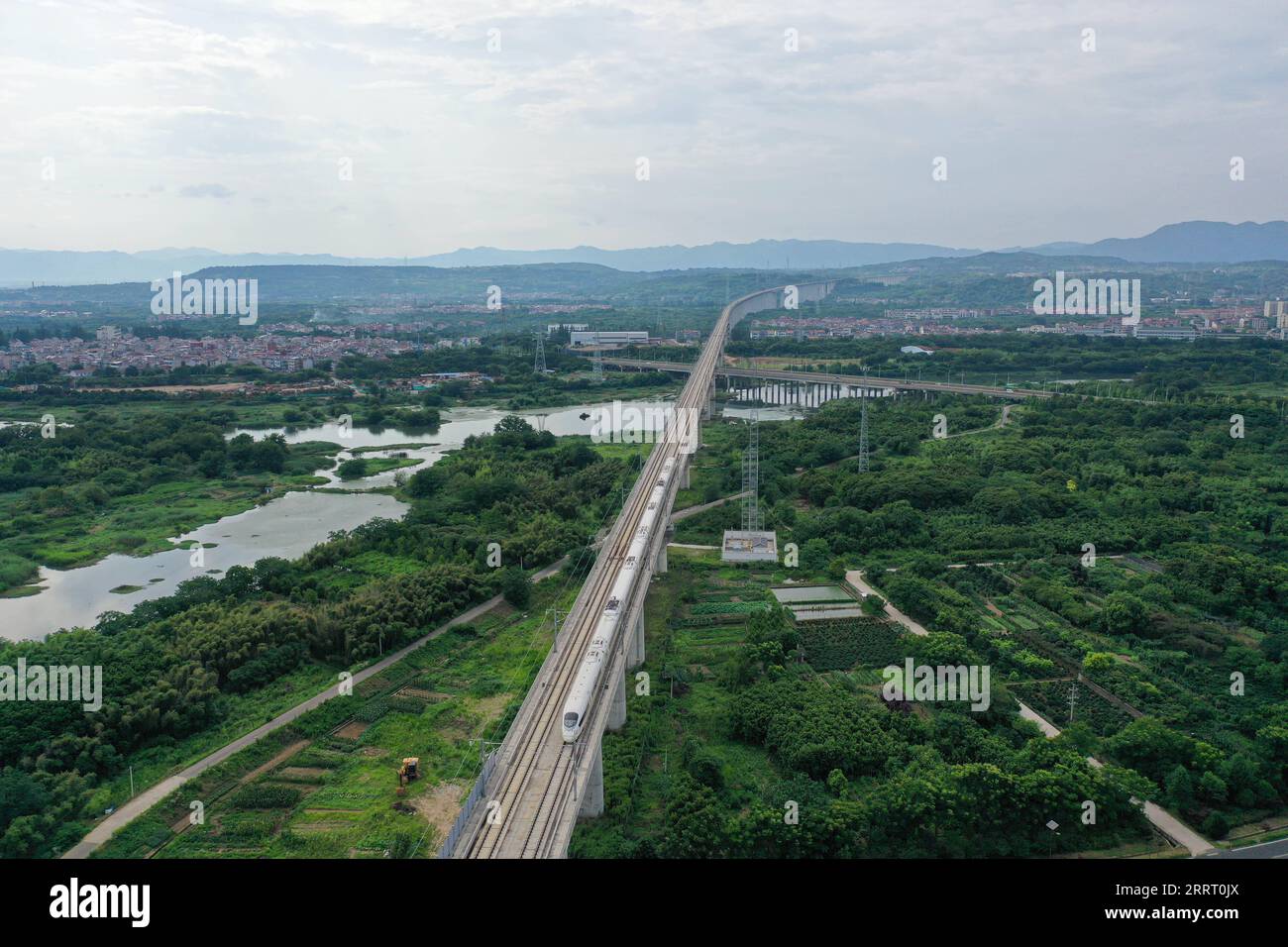 230620 -- SHENGZHOU, 20 giugno 2023 -- questa foto aerea scattata il 19 giugno 2023 mostra un treno proiettile che corre sulla ferrovia interurbana Hangzhou-Shaoxing-Taizhou a Shengzhou, nella provincia di Zhejiang nella Cina orientale. La ferrovia interurbana Hangzhou-Shaoxing-Taizhou è tra i primi progetti ferroviari ad alta velocità della Cina finanziati da un partenariato pubblico-privato PPP, con il settore privato che detiene lo status di holding. Dall'esercizio ufficiale della ferrovia nel gennaio 2022, più di 10 milioni di passeggeri hanno viaggiato lungo la ferrovia. La linea ferroviaria di 266 km, con una velocità prevista di 350 km/h, Foto Stock