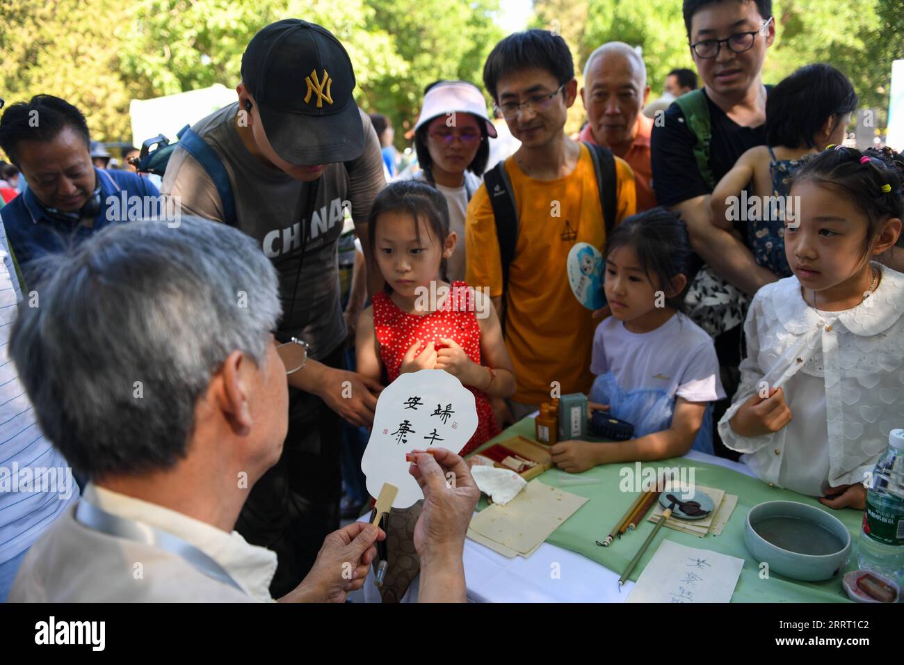 230622 -- PECHINO, 22 giugno 2023 -- Un calligrafo scrive auguri di fan per bambini al Longtan Park di Pechino, capitale della Cina, 22 giugno 2023. Durante il Dragon Boat Festival qui si sono svolte una serie di attività, tra cui gare in barca, spettacoli e giochi interattivi. CHINA-BEIJING-DRAGON BOAT FESTIVAL CN JUXHUANZONG PUBLICATIONXNOTXINXCHN Foto Stock