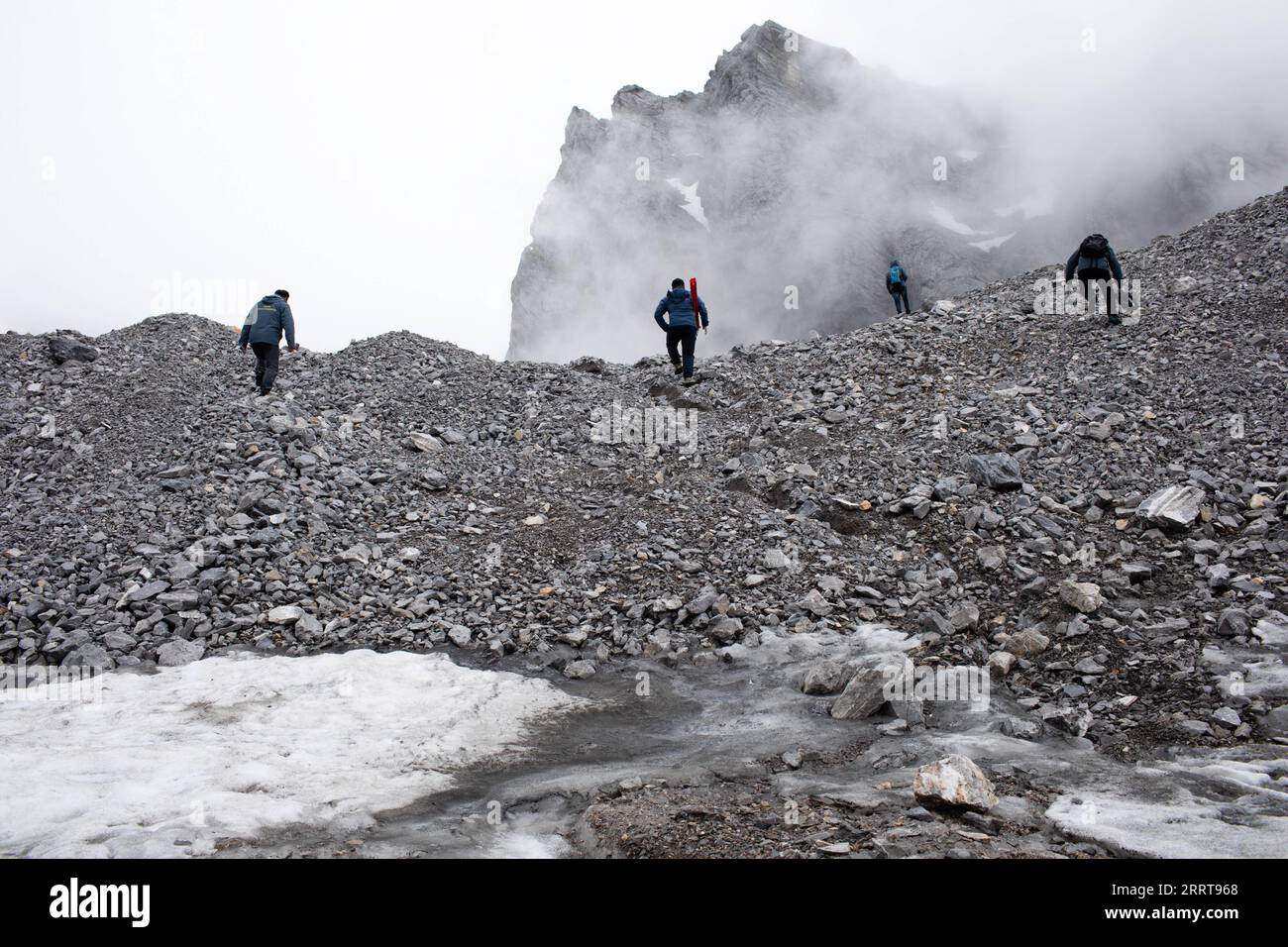 230707 -- LIJIANG, 7 luglio 2023 -- Wang Shijin 1st L si dirige verso il fiume Baishui No. 1 Glacier con compagni di squadra sulla Yulong Snow Mountain nella città di Lijiang, nella provincia dello Yunnan della Cina sud-occidentale, 19 giugno 2023. La Yulong Snow Mountain Cryosphere and Sustainable Development Field Science Observation and Research Station, istituita dal Northwest Institute of Eco-Environment and Resources of Chinese Academy of Sciences, si trova nella città di Lijiang nella provincia dello Yunnan nella Cina sud-occidentale. Dal 2006, i ricercatori hanno regolarmente monitorato le condizioni del ghiacciaio n. 1 del fiume Baishui e del suo ambiente circostante Foto Stock