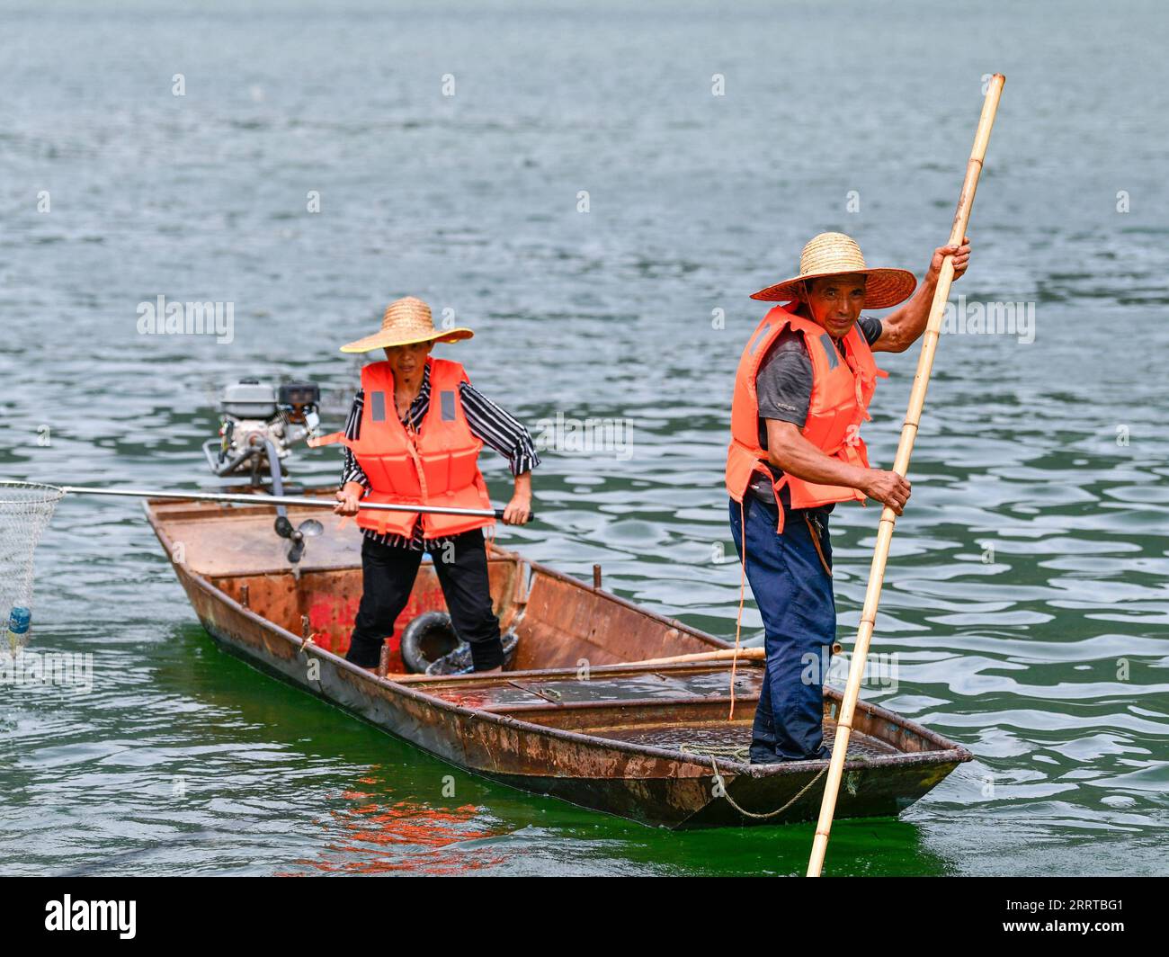 230712 -- WENG AN, 12 luglio 2023 -- Lu Xiyong and ran Maoying clean up floating garbage on the Wujiang River in Zhucang Township of Weng An County, South West China S Guizhou Province, 11 luglio 2023. Lu e Ran sono abitanti del villaggio che sono cresciuti lungo il fiume Wujiang e si sono sposati nel 1986. Per decenni, la coppia prese l'iniziativa di ripulire i rifiuti galleggianti lungo il fiume Wujiang e promuovere la protezione ambientale mentre lavorava sui traghetti. Sotto l'influenza della coppia, più di dieci abitanti locali hanno partecipato al lavoro volontario di gestione del fiume Wujiang e protecti Foto Stock