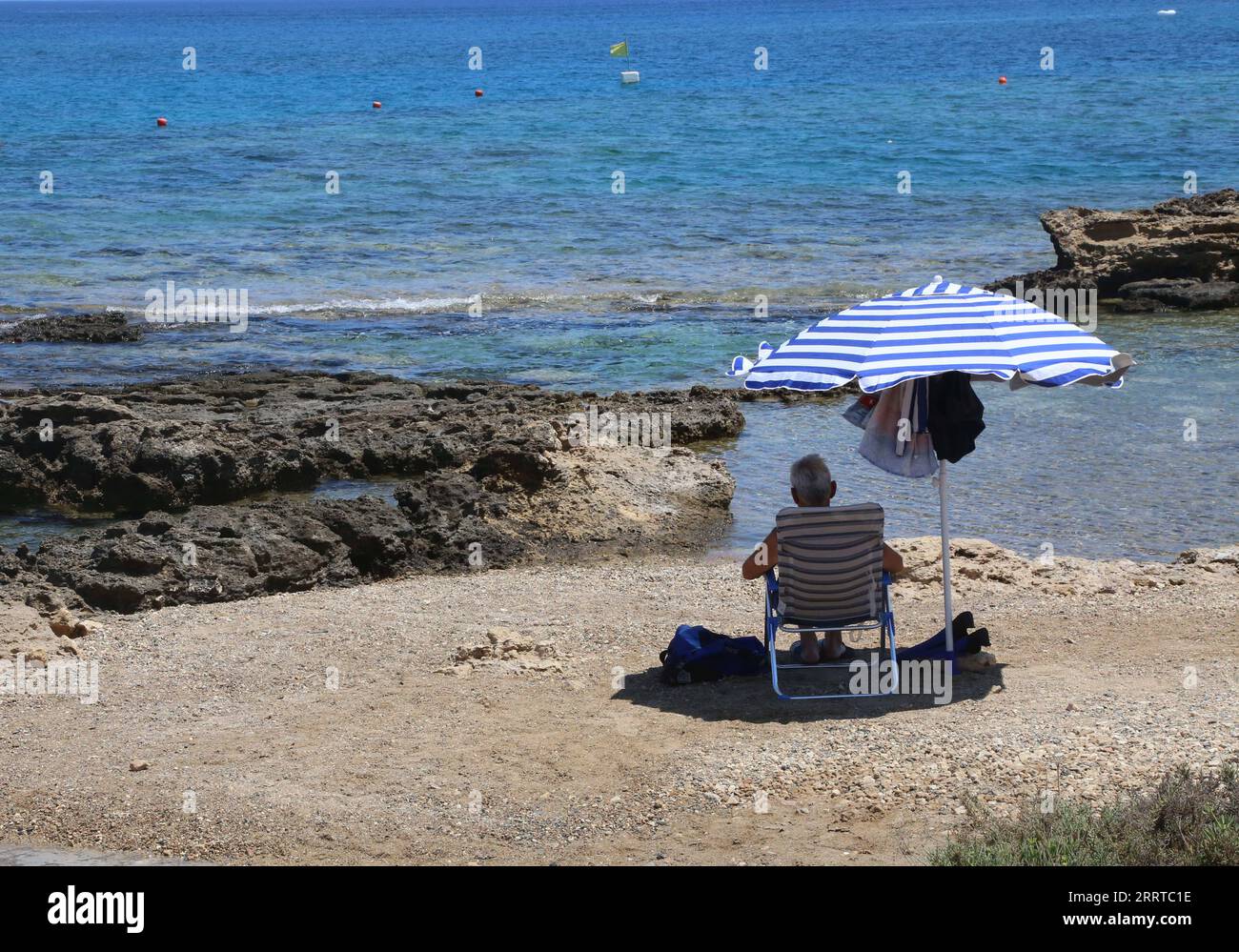 230714 -- NICOSIA, 14 luglio 2023 -- Un uomo riposa sotto un ombrellone su una spiaggia a Protaras, Cipro, 14 luglio 2023. Un'ondata di caldo che ha inghiottito gran parte dell'Europa all'inizio di questa settimana ha raggiunto Cipro, con 41 gradi Celsius registrati a Nicosia, il servizio meteorologico del paese ha dichiarato giovedì. Prevede che le temperature saliranno a 43 gradi Celsius il venerdì e resteranno oltre i 25 gradi Celsius durante la notte, quindi ha emesso un allarme color ambra per le alte temperature che sarà in vigore dalle 21:00 di giovedì alle 18:00 di venerdì. ALLARME CIPRO-ONDE DI CALORE-AMBRA GuoxMingfang PUBLICATIONxNOTxINxCHN Foto Stock