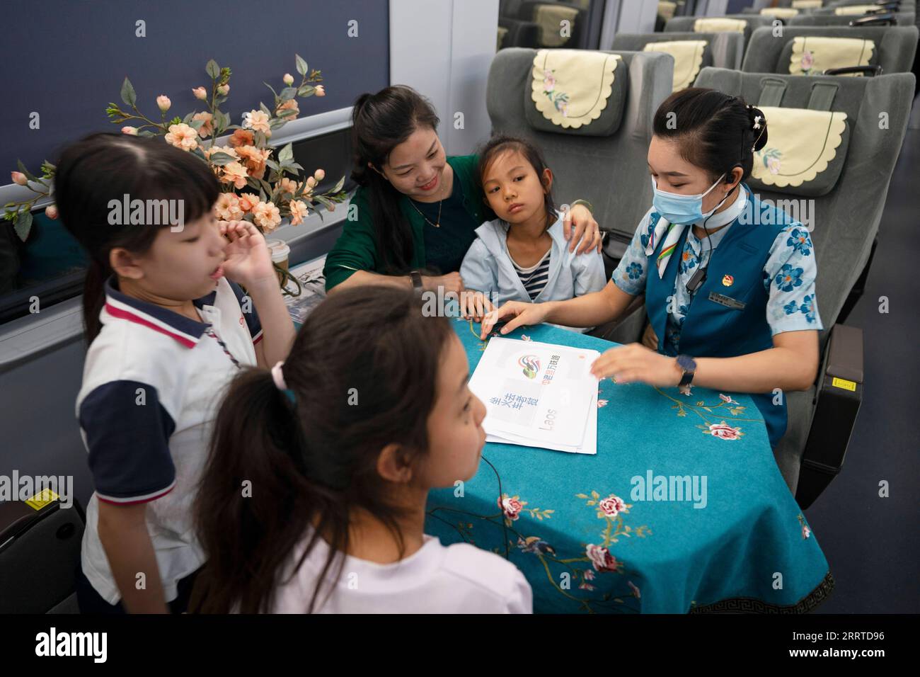 230718 -- MENGLA, 18 luglio 2023 -- Yi Bofeng R interagisce con i passeggeri a bordo del treno D887 il 16 luglio 2023. Yi Bofeng proviene dalla contea di Mengla, nella provincia dello Yunnan. Dopo essersi laureata come Lao Major in un college tecnico nella capitale provinciale Kunming nel 2020, è stata reclutata come assistente ferroviario sotto la China Railway Kunming Bureau Group Co., Ltd La China-Laos Railway, un importante progetto di cooperazione tra Belt e Road di alta qualità, ha iniziato le sue attività nel dicembre 2021. Yi era a bordo del primo treno della ferrovia, testimoniando il momento storico delle operazioni ferroviarie. railwa, 1.035 km Foto Stock
