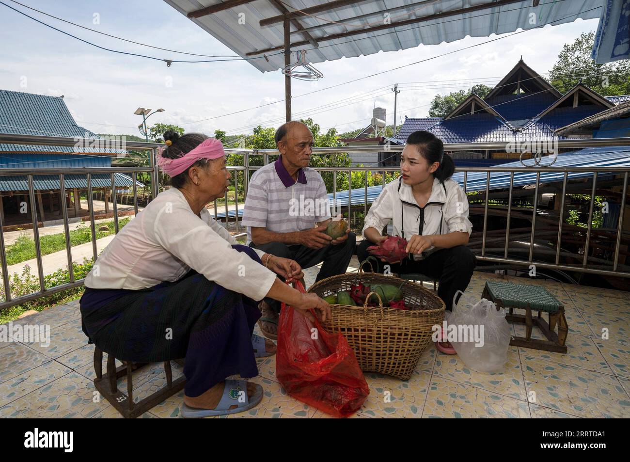 230718 -- MENGLA, 18 luglio 2023 -- Yi Bofeng R parla con i suoi nonni nella contea di Mengla, nella provincia dello Yunnan della Cina sud-occidentale, 16 luglio 2023. Yi Bofeng proviene dalla contea di Mengla, nella provincia dello Yunnan. Dopo essersi laureata come Lao Major in un college tecnico nella capitale provinciale Kunming nel 2020, è stata reclutata come assistente ferroviario sotto la China Railway Kunming Bureau Group Co., Ltd La China-Laos Railway, un importante progetto di cooperazione tra Belt e Road di alta qualità, ha iniziato le sue attività nel dicembre 2021. Yi era a bordo del primo treno della ferrovia, testimoniando il momento storico della ferrovia Foto Stock