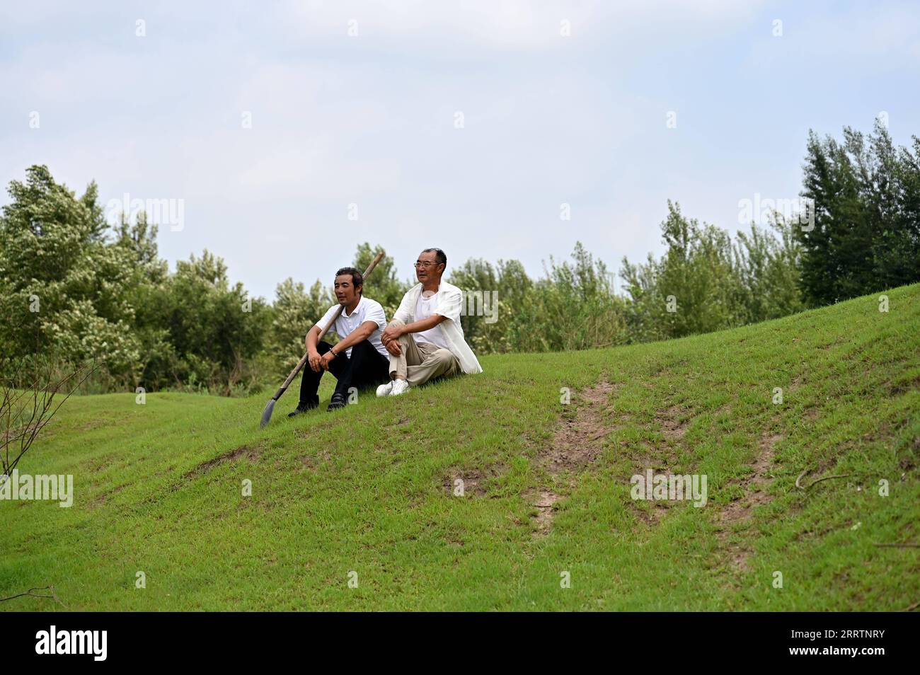 230803 -- TONGLIAO, 3 agosto 2023 -- Bai Shun R e suo figlio riposano su un prato a Bulteger Gacha, Horqin ala sinistra bandiera posteriore della città di Tongliao, regione autonoma della Mongolia interna della Cina settentrionale, 2 agosto 2023. Situato nel centro della Horqin Sandy Land, Bulteger Gacha, un piccolo villaggio nella bandiera posteriore dell'ala sinistra di Horqin della città di Tongliao, soffriva di desertificazione. Dal 2002, Bai Shun, un contadino mongolo locale, ha portato la sua famiglia a radicare in questo villaggio e a dedicarsi al controllo della desertificazione. Il tasso di sopravvivenza degli alberi piantati era basso all'inizio a causa della mancanza di esp Foto Stock
