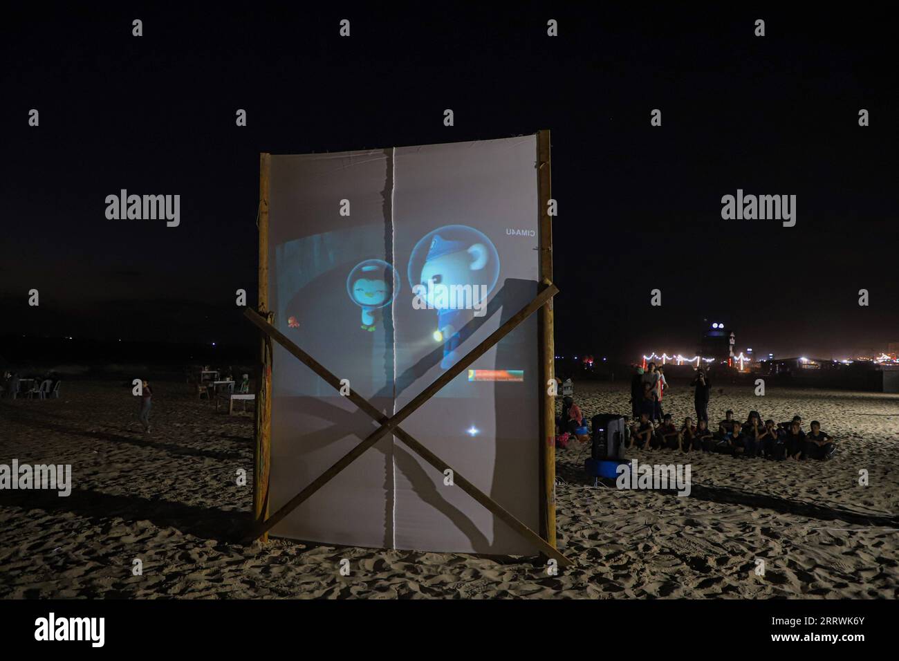 230815 -- GAZA, 15 agosto 2023 -- i palestinesi guardano un film su un grande schermo installato su una spiaggia nella città di Gaza, il 10 agosto 2023. Entusiasti e grati per questa iniziativa di creare un cinema all'aperto gratuito, decine di spettatori di cinema locali di varie età si riunirono davanti al grande schermo dopo il tramonto. Guardavano film di diversi generi seduti su sedie convertite da pneumatici rotti riciclati. Foto di /Xinhua TO GO WITH Feature: Il cinema all'aperto eco-compatibile a Gaza porta gioia ai palestinesi MIDEAST-GAZA CITY-OPEN-AIR CINEMA RizekxAbdeljawad PUBLICATIONxNOTxINxCHN Foto Stock