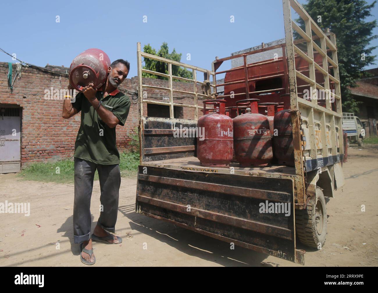 230831 -- AMRITSAR, 31 agosto 2023 -- Un lavoratore consegna bombole di gas di cottura GPL in una zona residenziale nel distretto di Amritsar, nello stato settentrionale del Punjab, in India, 30 agosto 2023. Il governo indiano ha deciso martedì di ridurre il prezzo del gas di cottura bombola GPL utilizzata nelle famiglie di 200 rupie indiane circa 2,42 dollari USA per bombola, ha detto il ministro dell'informazione e della radiodiffusione Anurag Thakur. Str/Xinhua INDIA-PUNJAB-ECONOMY-PREZZO DEL GAS DI COTTURA JavedxDar PUBLICATIONxNOTxINxCHN Foto Stock