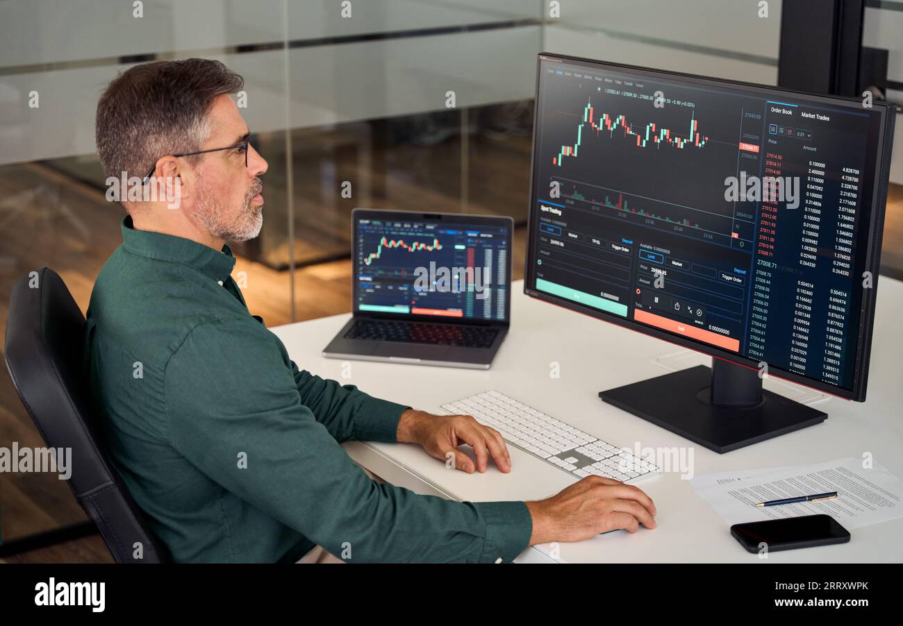 Investitore commerciale maturo e impegnato che analizza il mercato di trading degli investimenti. Foto Stock