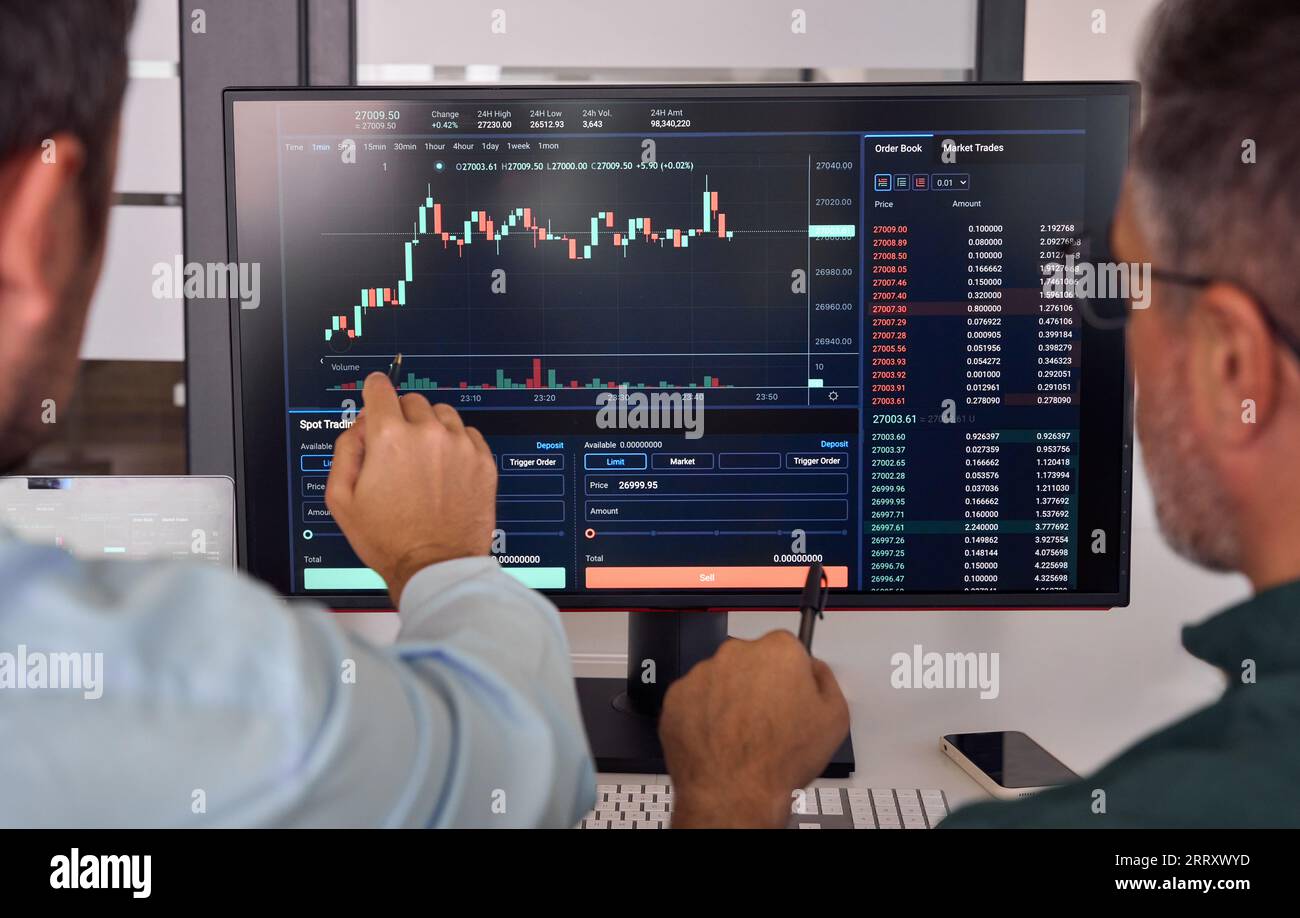 Due trader che discutono dei dati finanziari del mercato cripto durante la riunione. Primo piano Foto Stock