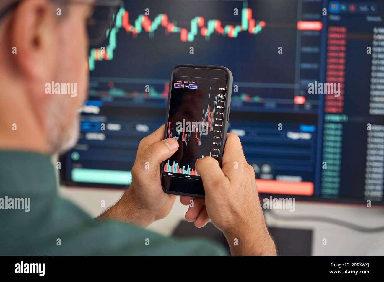Investitore trader che analizza il mercato mobile degli investimenti delle azioni crittografiche. A spalla Foto Stock