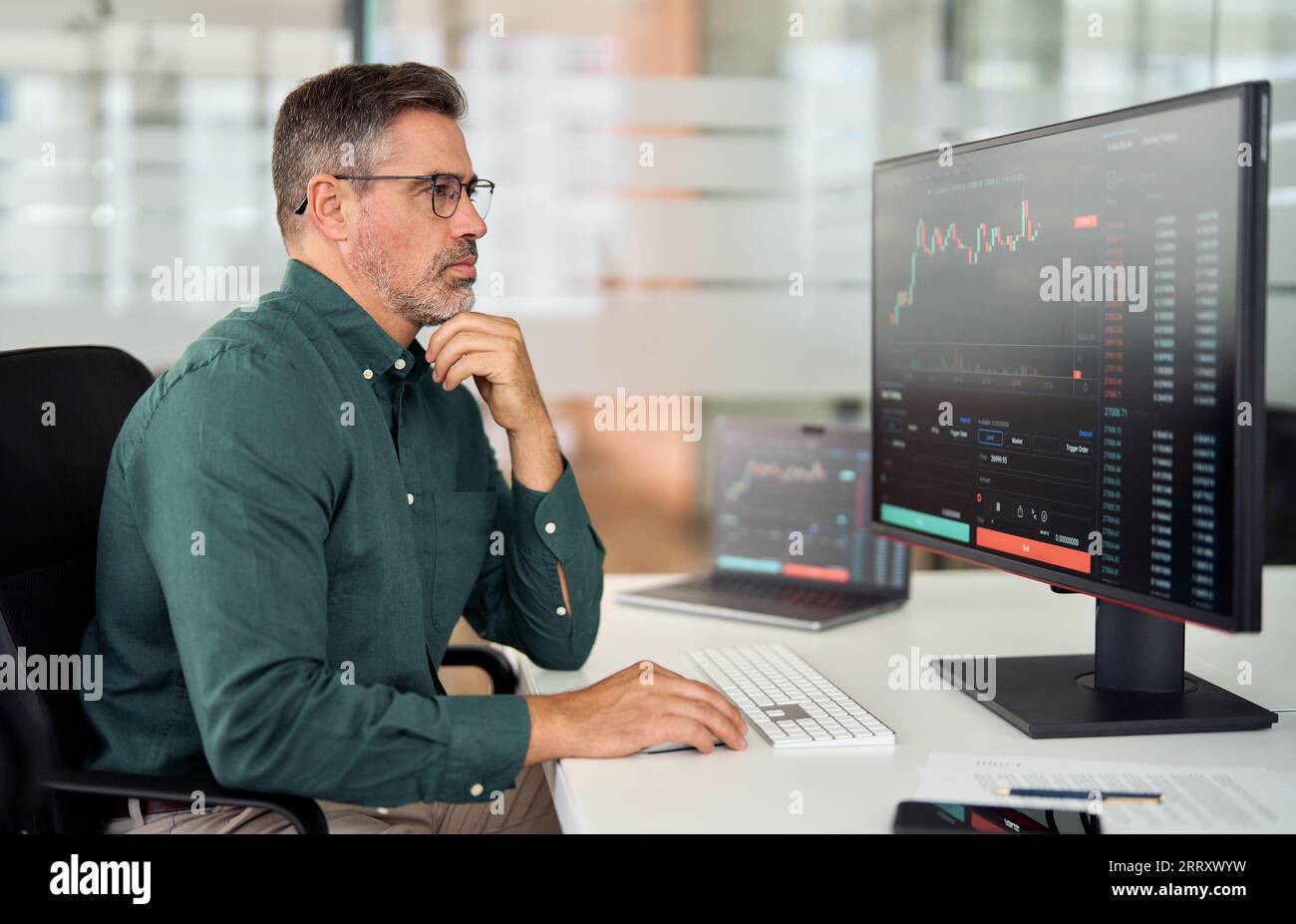 Broker di criptovalute di mezza età che analizza la crescita dei prezzi dei mercati azionari online. Foto Stock