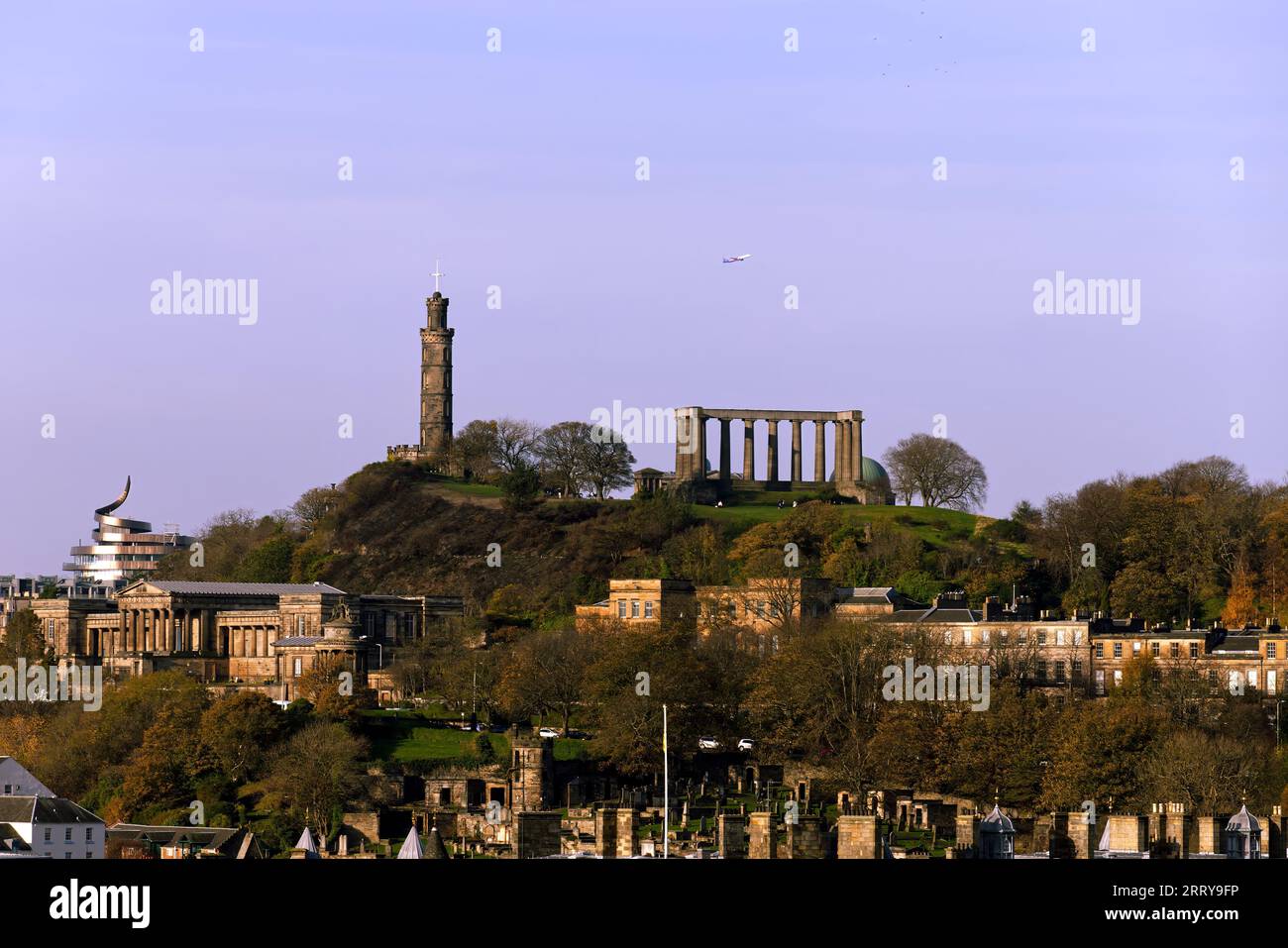 Calton Hill e Soaring Skies: Un aereo decolla in una splendida giornata Foto Stock