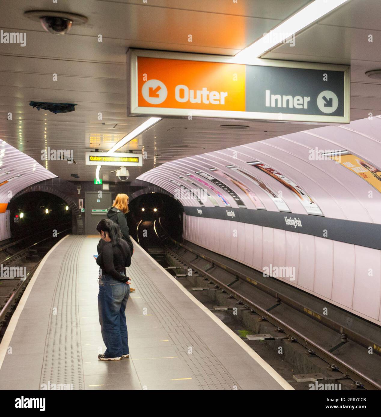 Stazione di Kinning Park sulla metropolitana SPT Glasgow che mostra la stretta piattaforma dell'isola e attende i passeggeri con le luci di un treno in avvicinamento Foto Stock