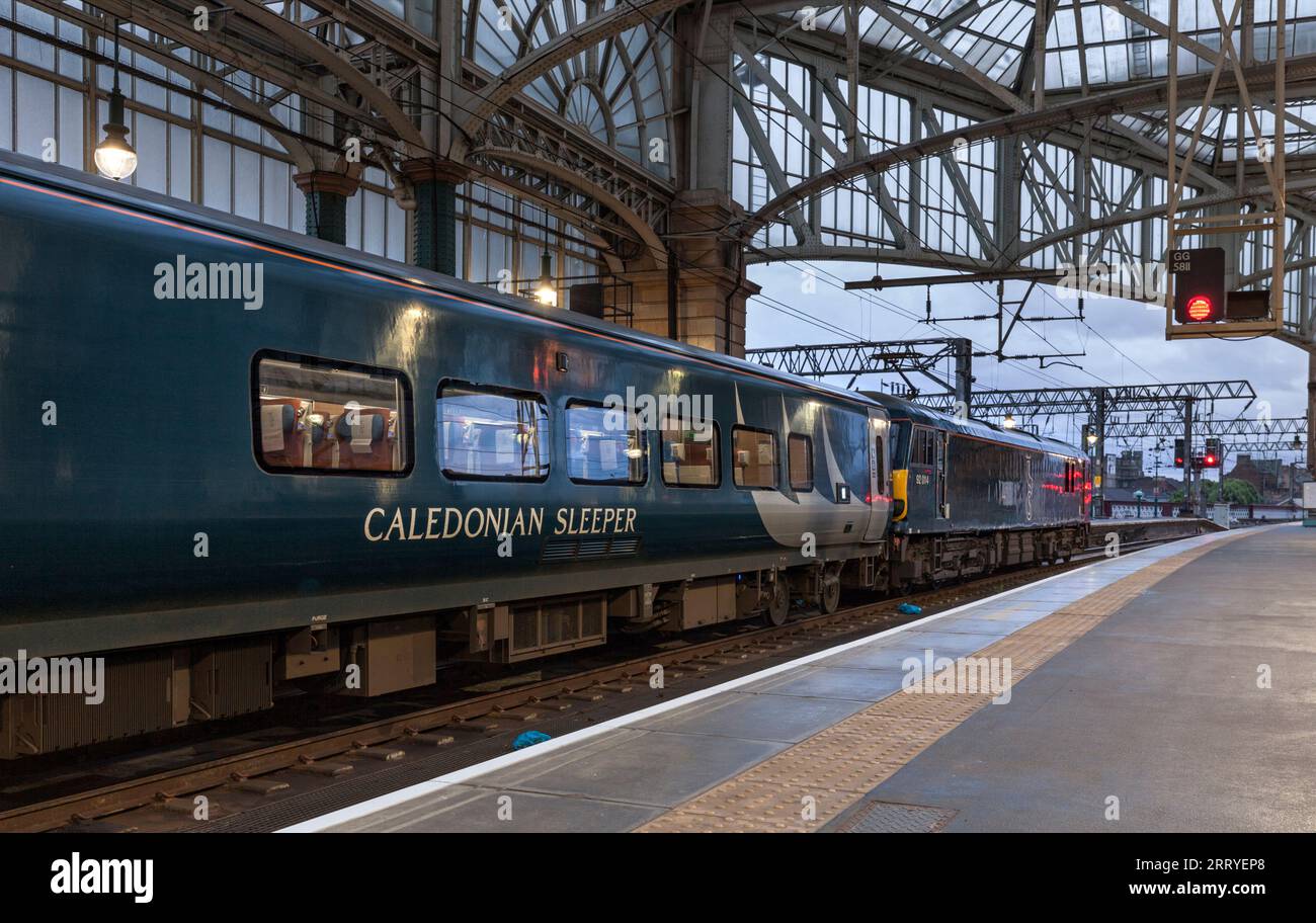 Il treno caledoniano a dorso di pianura in attesa di partire dalla stazione centrale di Glasgow con una locomotiva elettrica di classe 92 Foto Stock