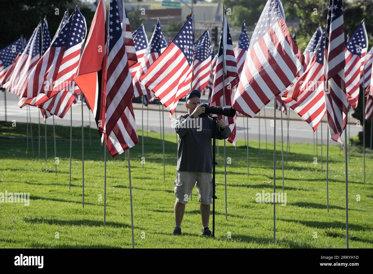 Chuck Utash scatta fotografie all'esposizione Waves of Flags in onore delle vite perse negli attacchi terroristici dell'11 settembre 2001, con quasi 3.000 bandiere degli Stati Uniti nell'Alumni Park presso la Pepperdine University lungo Pacific Coast Highway e Malibu Canyon Road, una per ogni vittima innocente, inclusa una bandiera nazionale per ogni paese straniero che ha perso un cittadino nell'attacco, sabato 9 settembre 2023, a Malibu, calib. Foto Stock