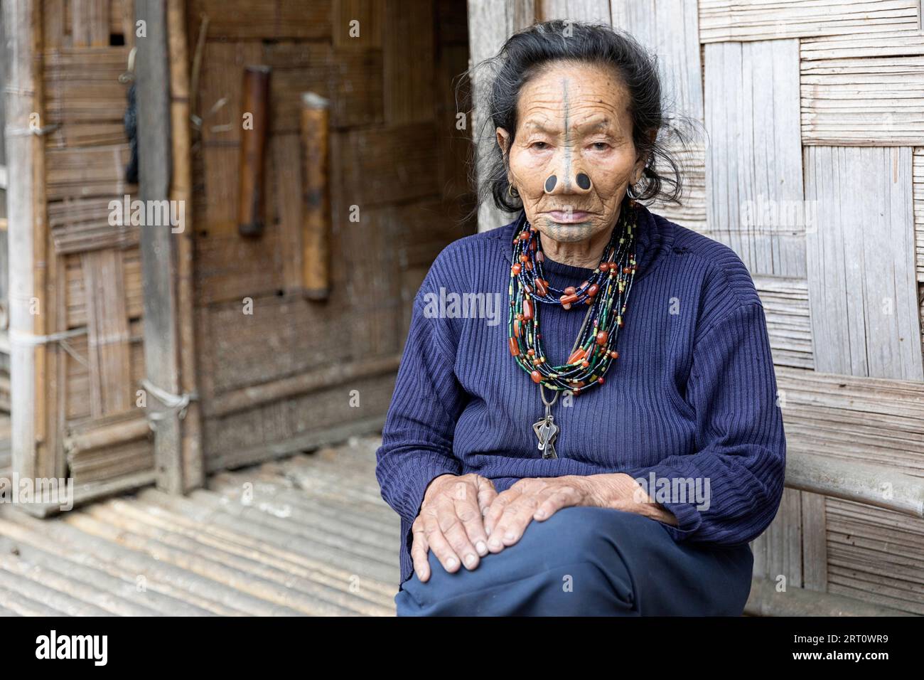 Ritratto di anziana donna tribale di minoranza etnica Apatani indiana con tappi neri in legno e tatuaggi tradizionali per il viso, Arunachal Pradesh, India Foto Stock