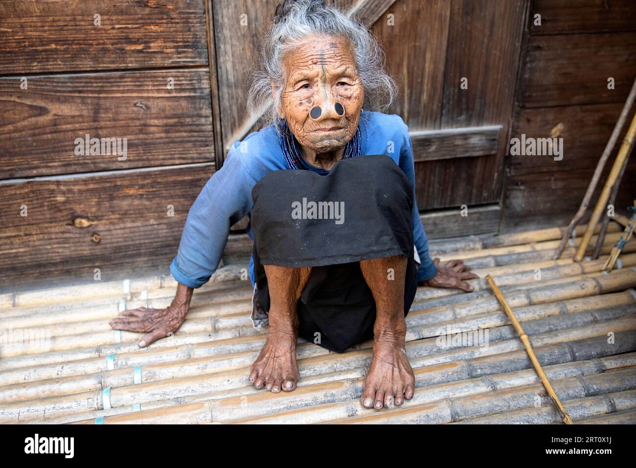 Ritratto di anziana donna tribale di minoranza etnica Apatani indiana con tappi neri in legno e tatuaggi tradizionali per il viso, Arunachal Pradesh, India Foto Stock