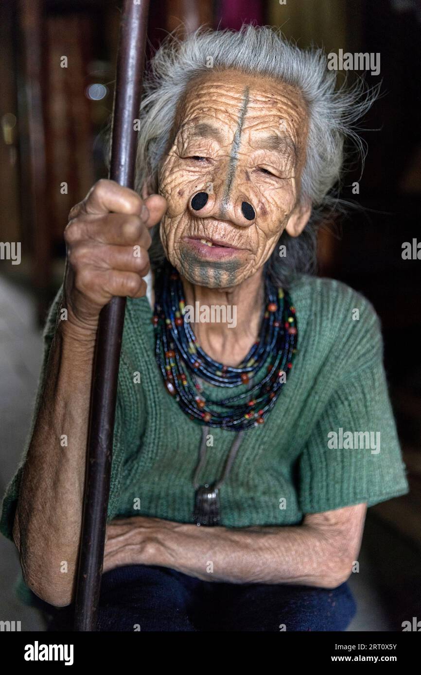 Ritratto di anziana donna tribale di minoranza etnica Apatani indiana con tappi neri in legno e tatuaggi tradizionali per il viso, Arunachal Pradesh, India Foto Stock