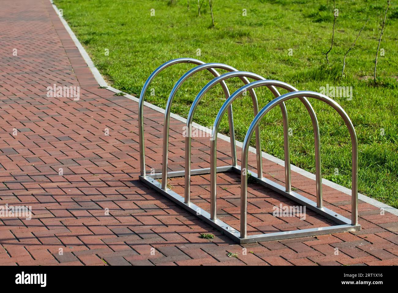 Moderno parcheggio per biciclette in acciaio inox con fondo in lastre di pavimentazione Foto Stock