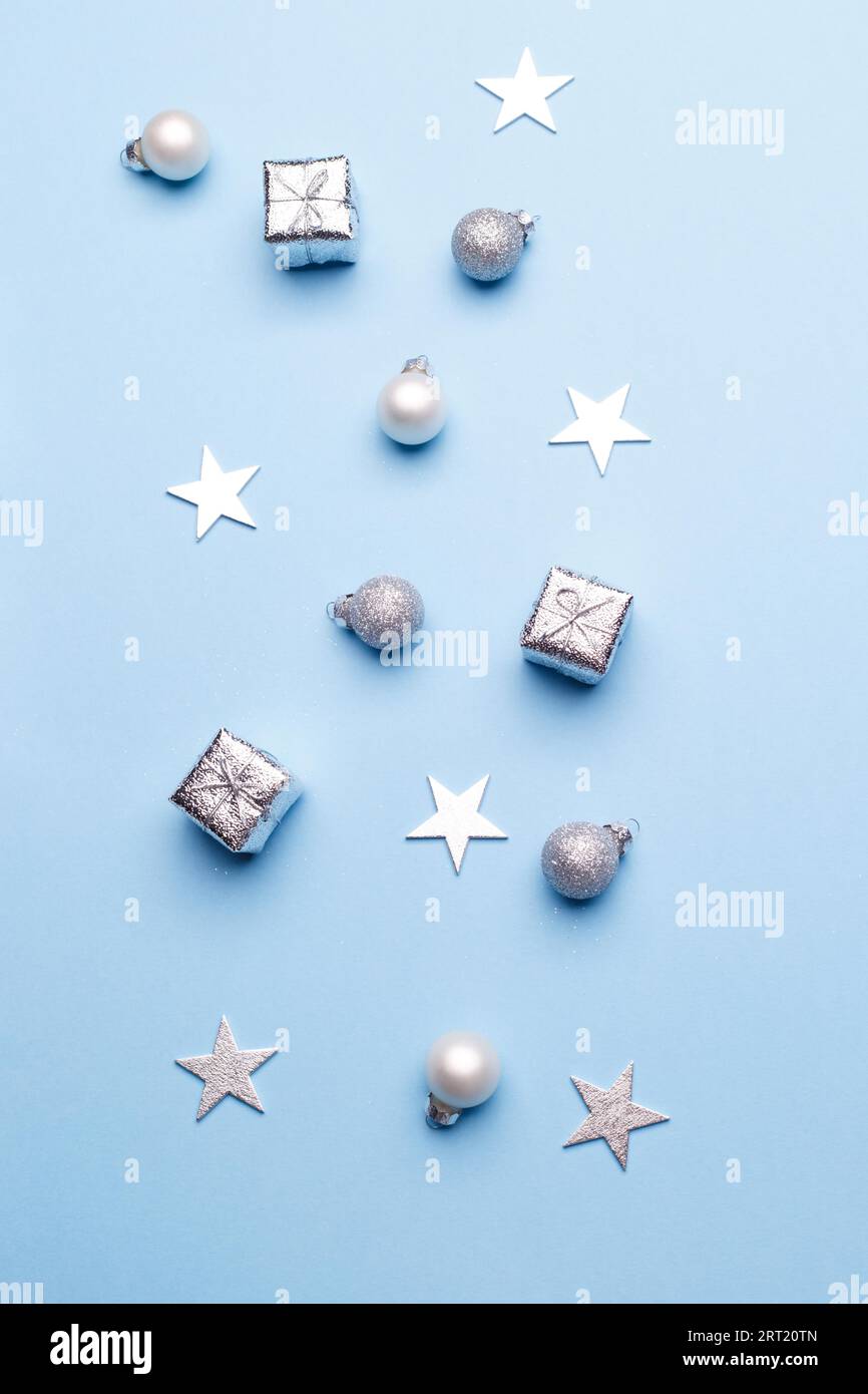 Decorazioni in argento di Natale su sfondo blu trendy, modello di biglietto di auguri Foto Stock