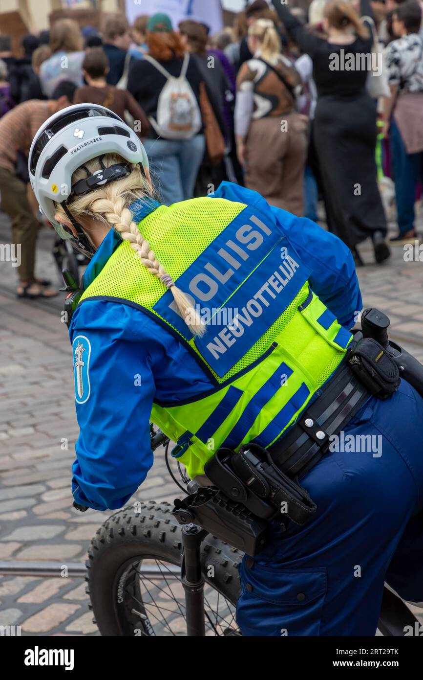 Negoziatore della polizia in bicicletta tra i partecipanti al “fine del silenzio!” Manifestazione contro il razzismo e il fascismo nel governo finlandese. Foto Stock