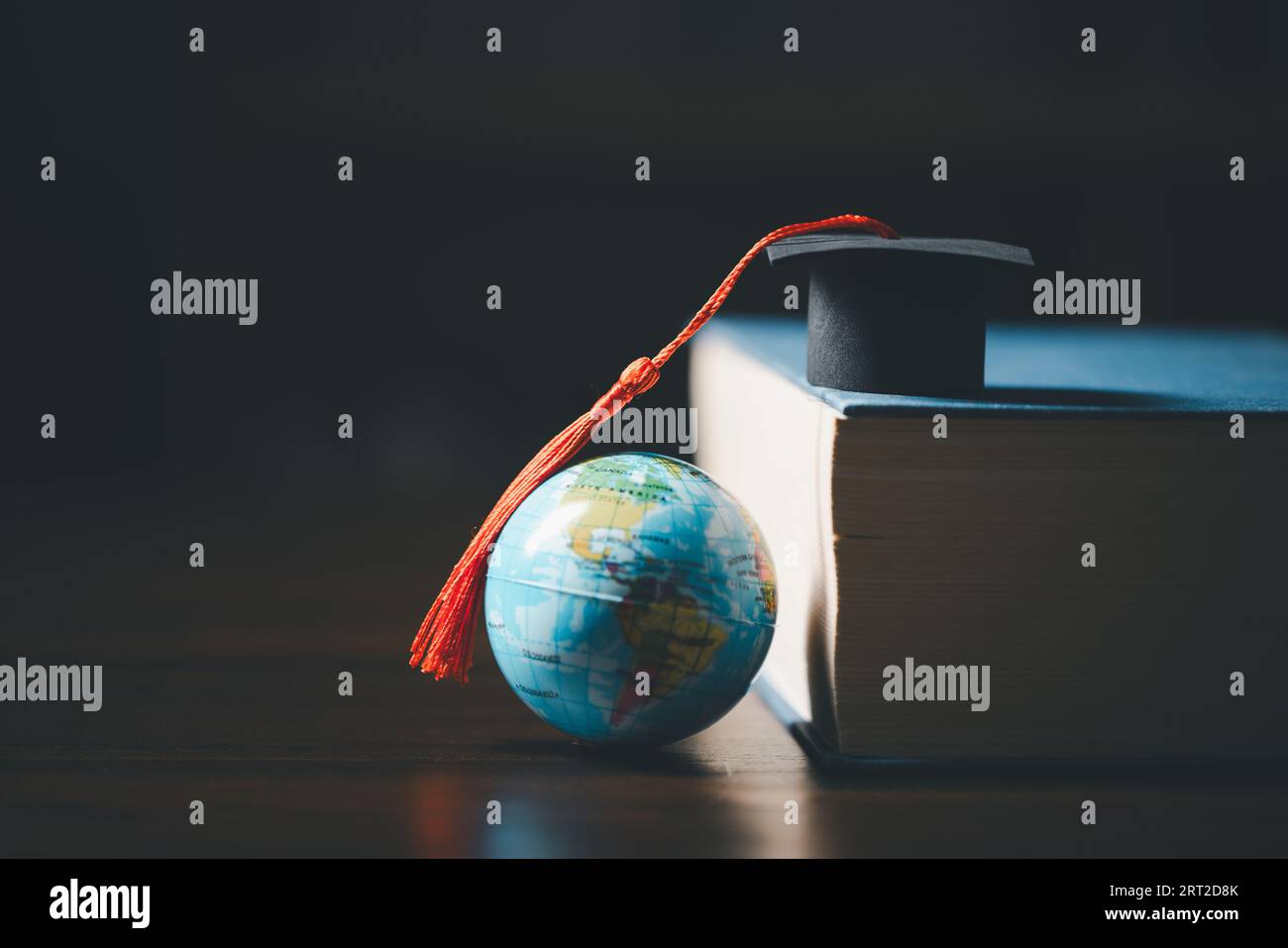 Laurea all'estero Conceptual internazionale, Graduation HAT on TOP Earth Globe model MAP.Congratulazioni ai laureati, studi portano al successo in Foto Stock