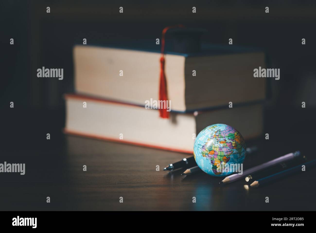 Laurea all'estero Conceptual internazionale, Graduation HAT on TOP Earth Globe model MAP.Congratulazioni ai laureati, studi portano al successo in Foto Stock