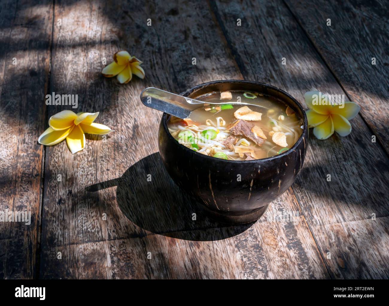 Soto Batok, una tradizionale zuppa di manzo giavanese con verdure e riso, servita in una tradizionale ciotola fatta di guscio di cocco. Foto Stock