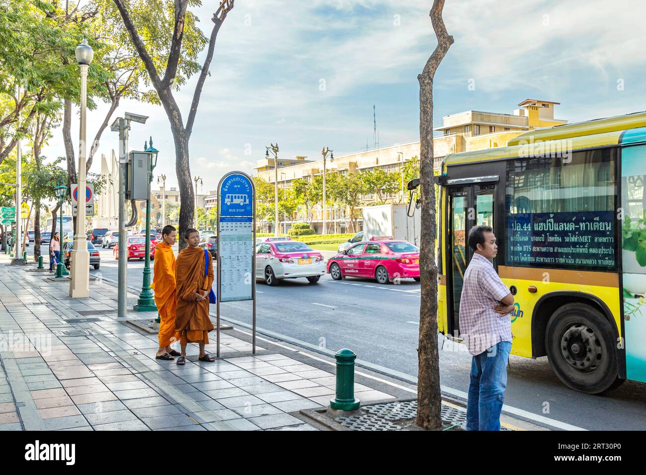 BANGKOK, THAILANDIA - 31 DICEMBRE 2017: Monaci e pedoni aspettano un autobus lungo Ratchadamnoen Road. Viaggiare in autobus è popolare tra il pub generale Foto Stock