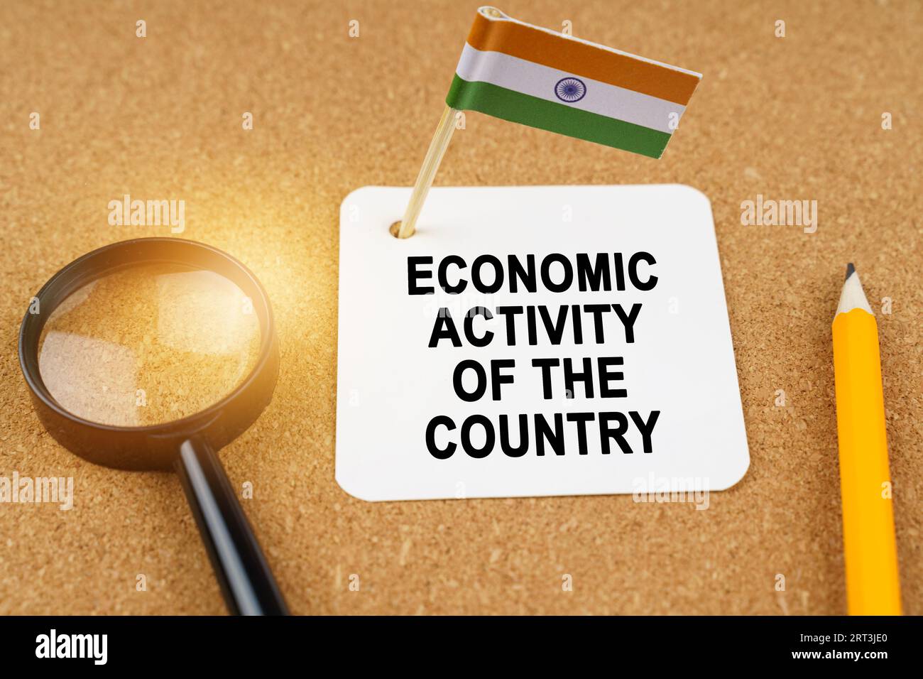 Economia e finanza. Sul tavolo ci sono una lente d'ingrandimento, una matita, la bandiera dell'India e un foglio di carta con l'iscrizione - atto economico Foto Stock