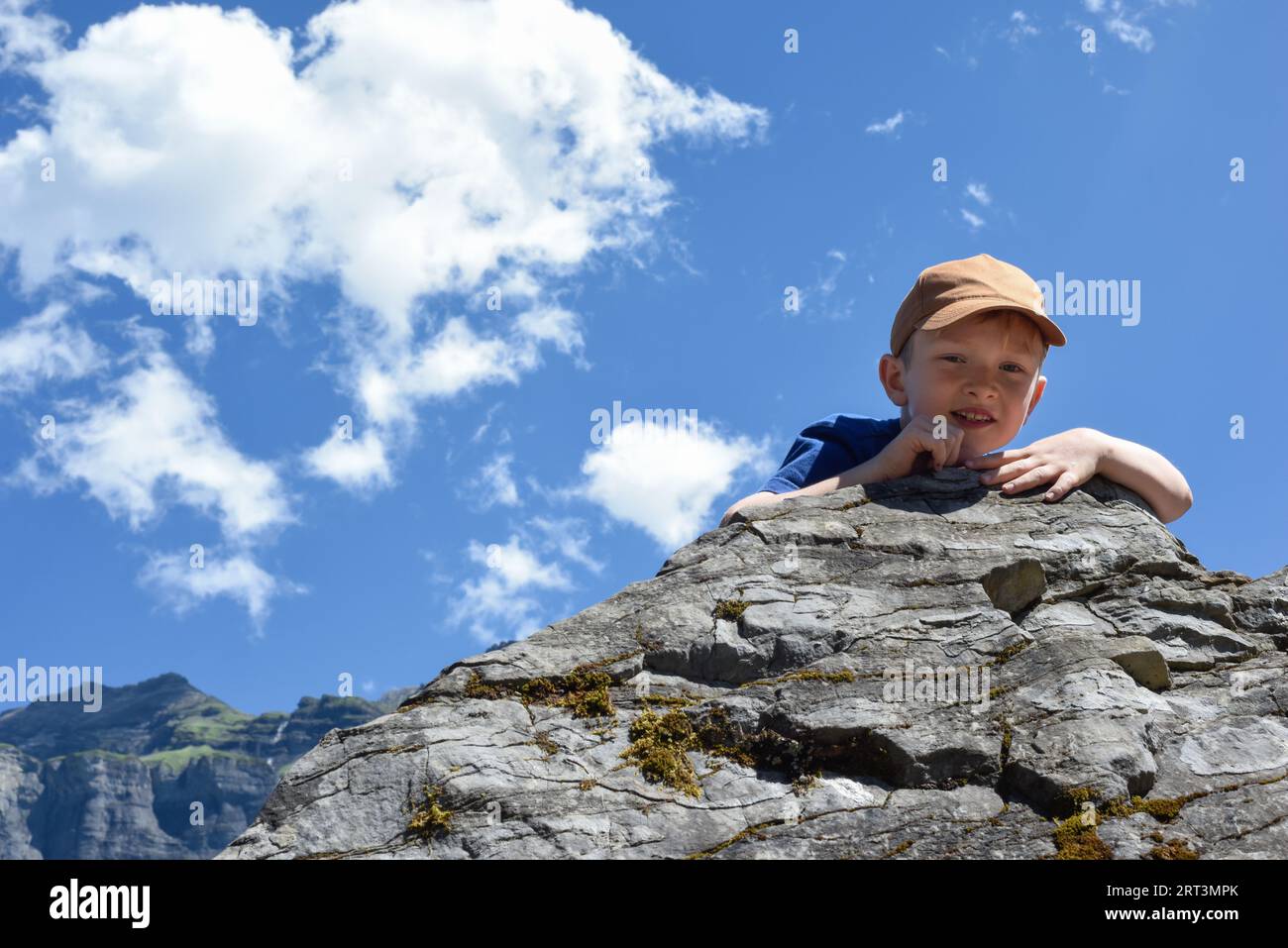Arrampicata su roccia per bambini durante un'avventura di esercizi all'aperto con paesaggi di montagna Foto Stock