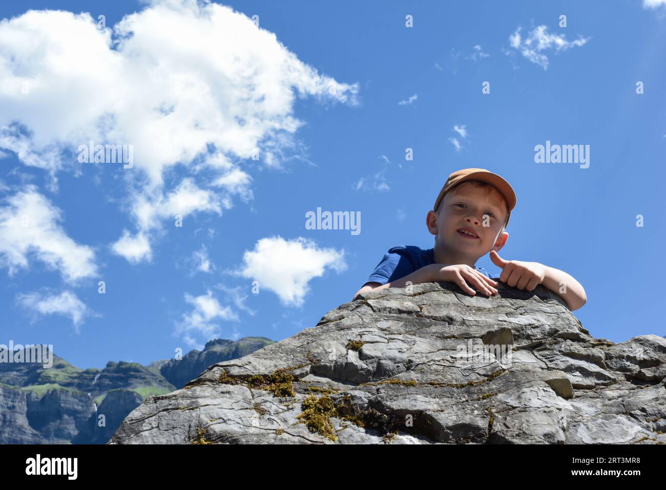 Arrampicata su roccia per bambini durante un'avventura di esercizi all'aperto con paesaggi di montagna Foto Stock