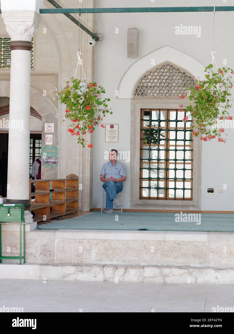 L'uomo siede accanto al portascarpe accanto all'ingresso della Moschea degli imperatori nella città di Sarajevo, Bosnia ed Erzegovina, 10 settembre 2023 Foto Stock