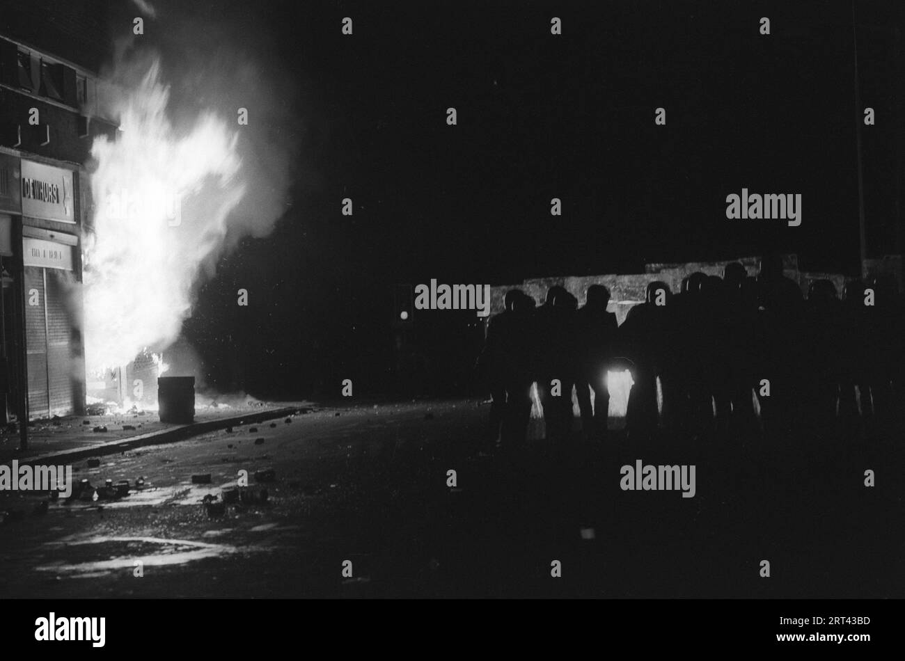 Toxteth Riots 1980s UK. Gli edifici sono incendiati, la polizia con gli scudi si muove in avanti per spingere indietro i rivoltosi e fare arresti. Toxteth, Liverpool, Inghilterra Regno Unito luglio 1981 HOMER SYKES Foto Stock