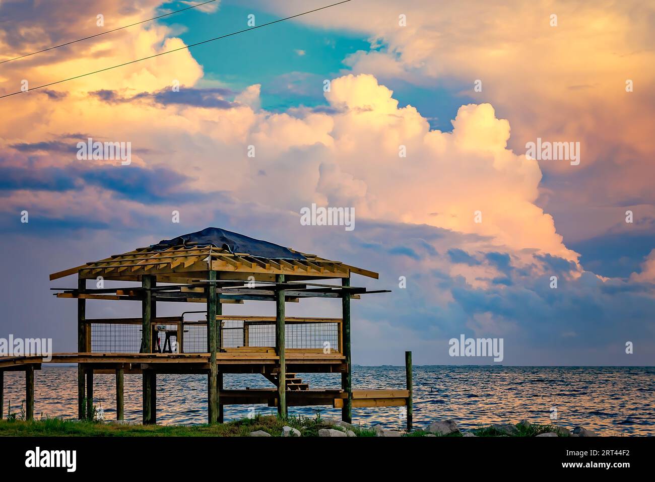 Il sole tramonta su un molo parzialmente finito a Coden Beach, il 2 settembre 2023, a Bayou la Batre, Alabama. Foto Stock