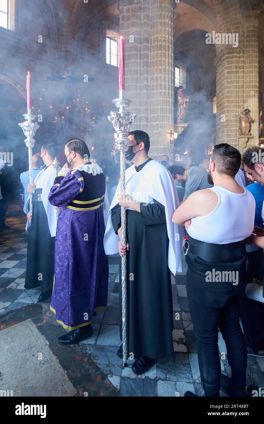 Jerez de la Frontera, Spagna - 10 settembre 2023: Costalero in primo piano accanto ad alcuni religiosi in attesa di passare sotto il passo durante la settimana Santa di Foto Stock