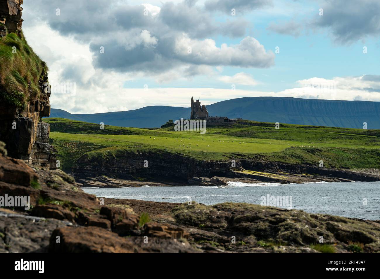 Castello di Classiebawn di fronte al monte Benbulben, visto da Mullaghmore Head, contea di Sligo, Irlanda Foto Stock