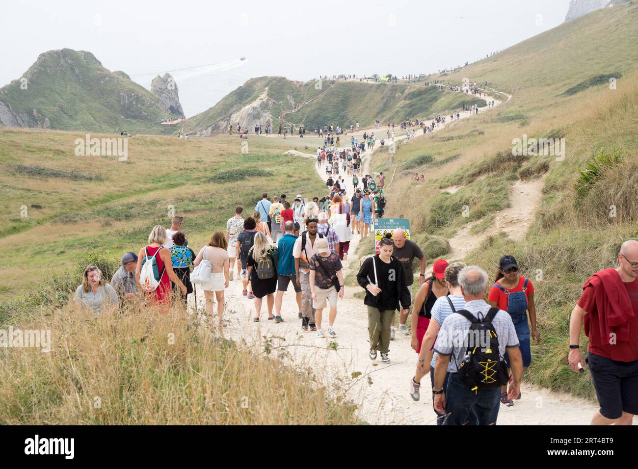 Dorset, 10 settembre 2023. Meteo Regno Unito. La spiaggia di Durdle Doors è piena di gente nonostante il tempo abbia fatto un giro di pioggia e cielo nuvoloso dopo due settimane di mini-ondata di calore che si è divertita in tutto il paese nel Regno Unito. Credito: Glosszoom/Alamy Live News Foto Stock