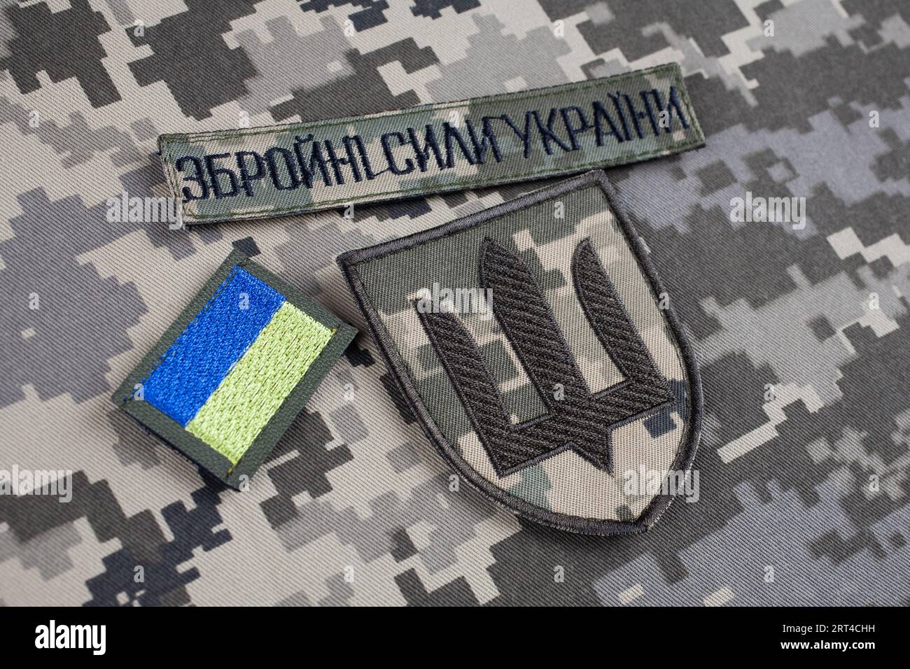 KIEV, UCRAINA - 6 ottobre 2022. Invasione russa in Ucraina 2022. Stemmi uniformi dell'esercito dell'Ucraina su sfondo uniforme mimetizzata. Testo in ukr Foto Stock
