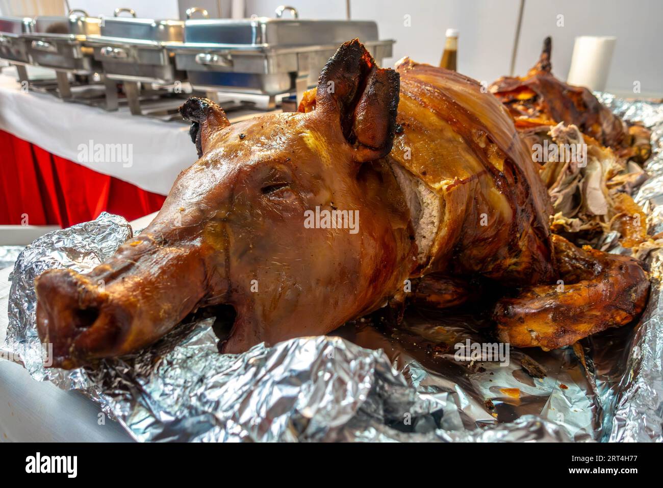 Un maiale arrosto o lechon viene tradizionalmente tagliato durante le celebrazioni filippine e gli eventi speciali. Foto Stock