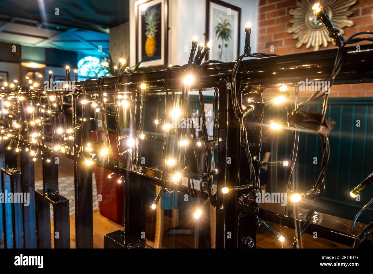 Luci bianche avvolte intorno a una barriera metallica in un bar per creare atmosfera e illuminazione Foto Stock