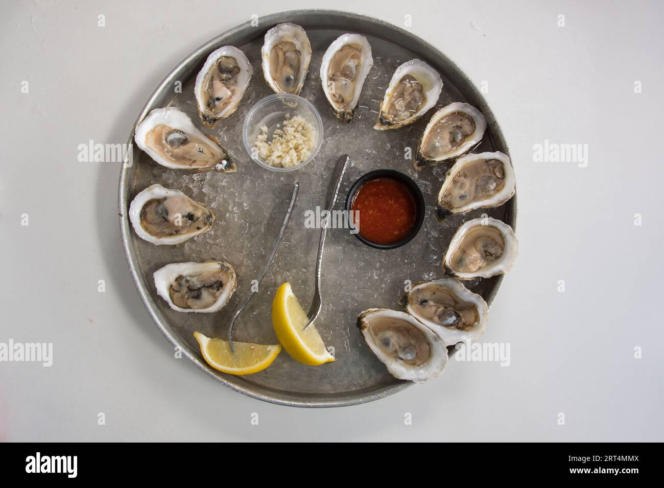 Un ordine di ostriche crude su mezzo guscio con spicchi di limone, rafano e salsa cocktail, Maine, USA Foto Stock