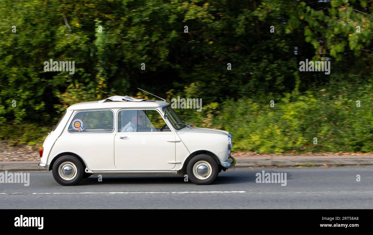 Milton Keynes, Regno Unito-10 settembre 2023: 1960 BMC MkI Mini bianco, Rover Mini, Austin Seven, auto che viaggia su una strada inglese. Foto Stock