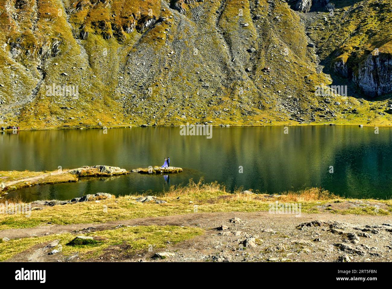 Coppia in un servizio fotografico di nozze sul lago Bâlea, posa mi ha ricordato la bellezza e la bestia Foto Stock
